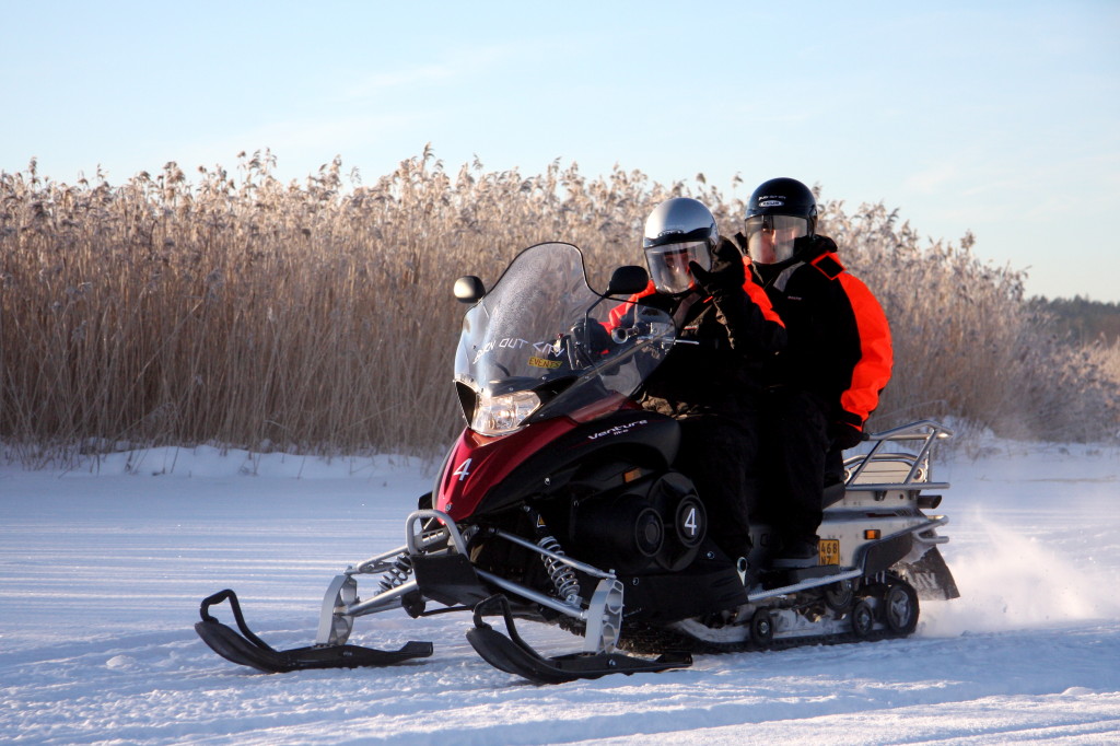 two persons on a snowmobile in the archipelago